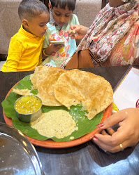 A family sharing a traditional meal at Sri Garuda Vihar